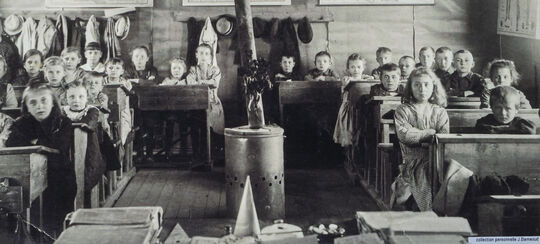 Photo d'archive de la classe de Le Maisnil vers 1930 avec les élèves derrière leur pupitre.